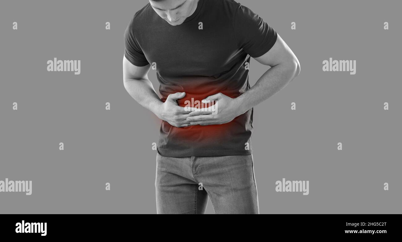 Man experiences abdominal cramps and stomach pain with food poisoning or bacterial infection. Stock Photo