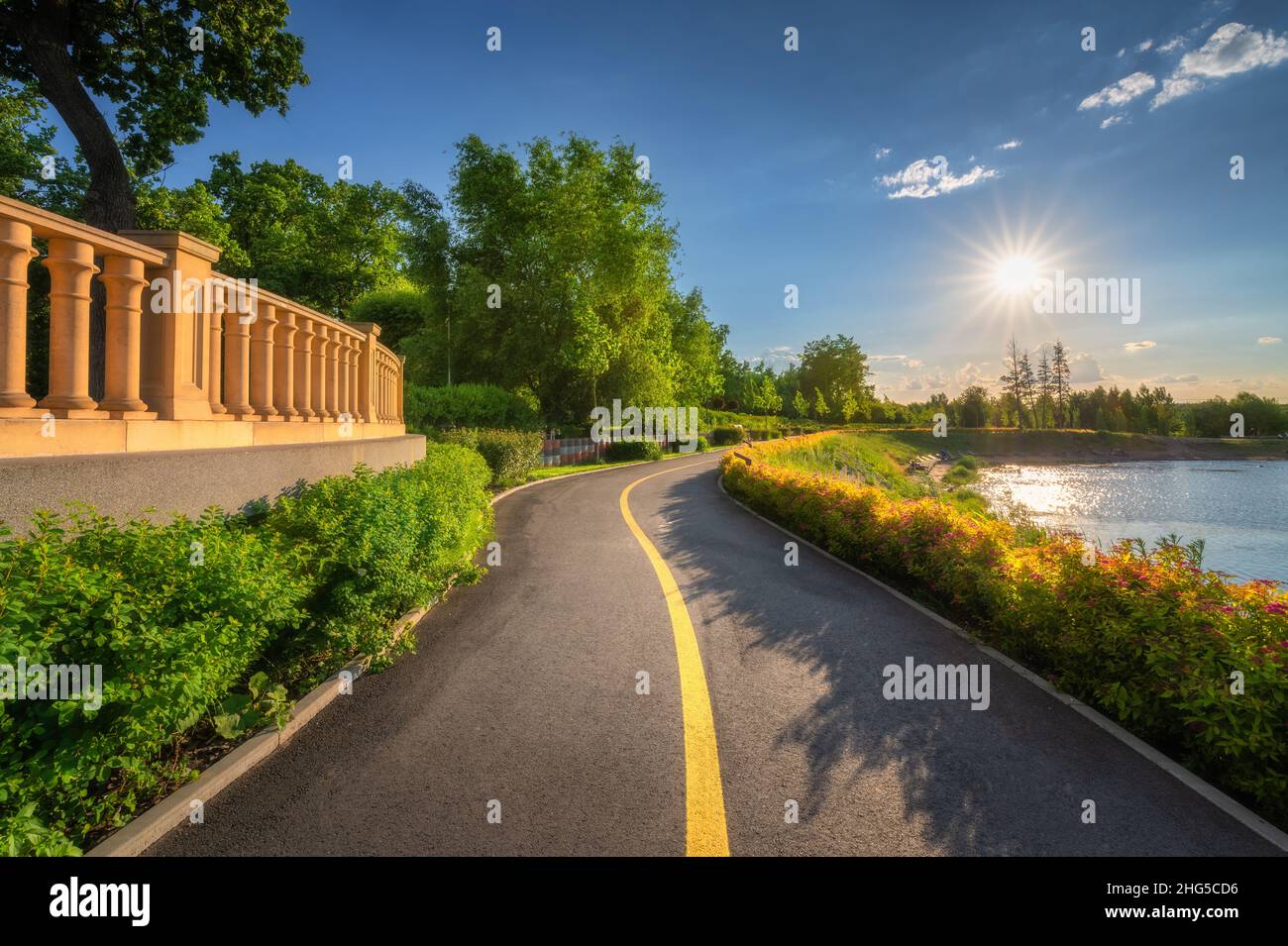 Beautiful road in park at sunset in summer. Colorful landscape with walkway Stock Photo