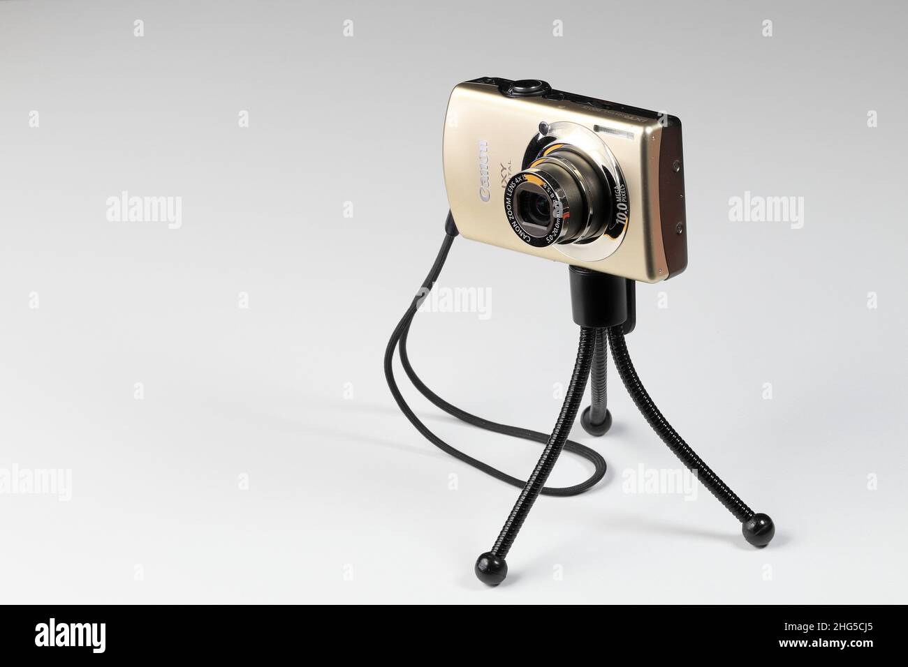 digital compact camera with hand strap and stretch lens on small tripod isolate on white background. Stock Photo