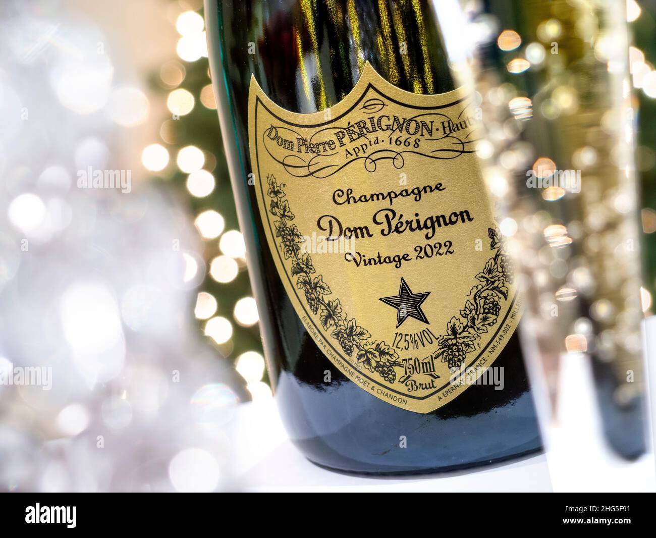 DOM PERIGNON Bottle and freshly poured flute of 2022 (post dated) Dom Perignon luxury vintage champagne with sparkling celebration lights Stock Photo