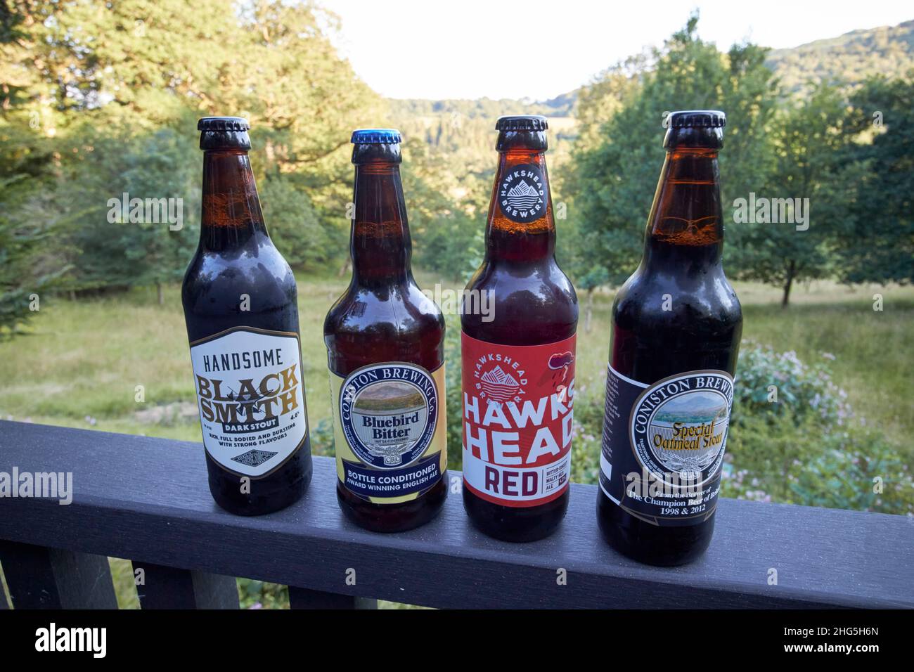 craft beers from local breweries including handsome brewery, coniston brewery and hawkshead brewery on a cabin handrail in skelwith bridge  lake distr Stock Photo