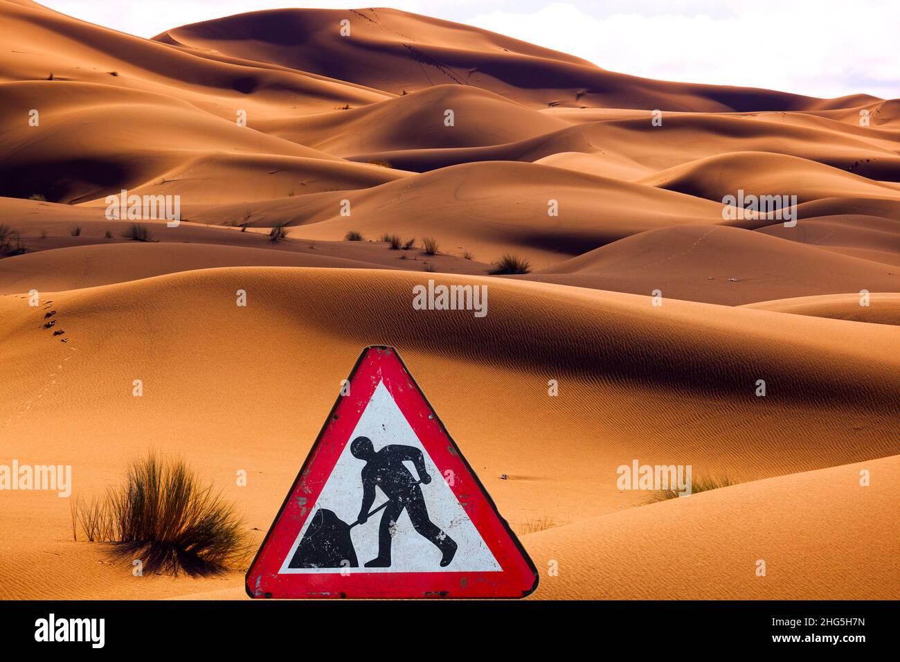 Men at work sign in Erg Chebbi Dunes Sahara Desert Morocco North Africa March Stock Photo