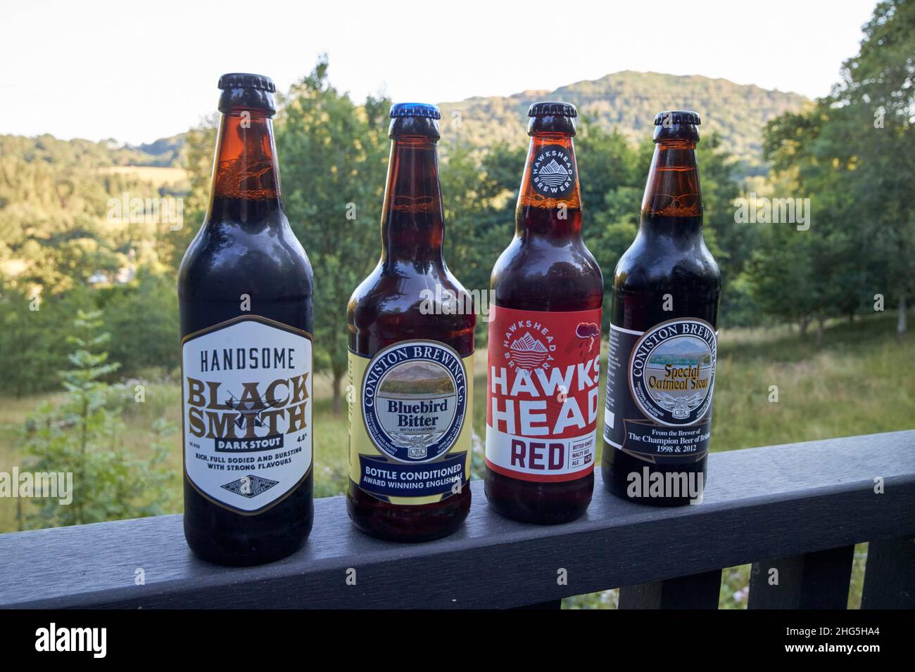 craft beers from local breweries including handsome brewery, coniston brewery and hawkshead brewery on a cabin handrail in skelwith bridge  lake distr Stock Photo