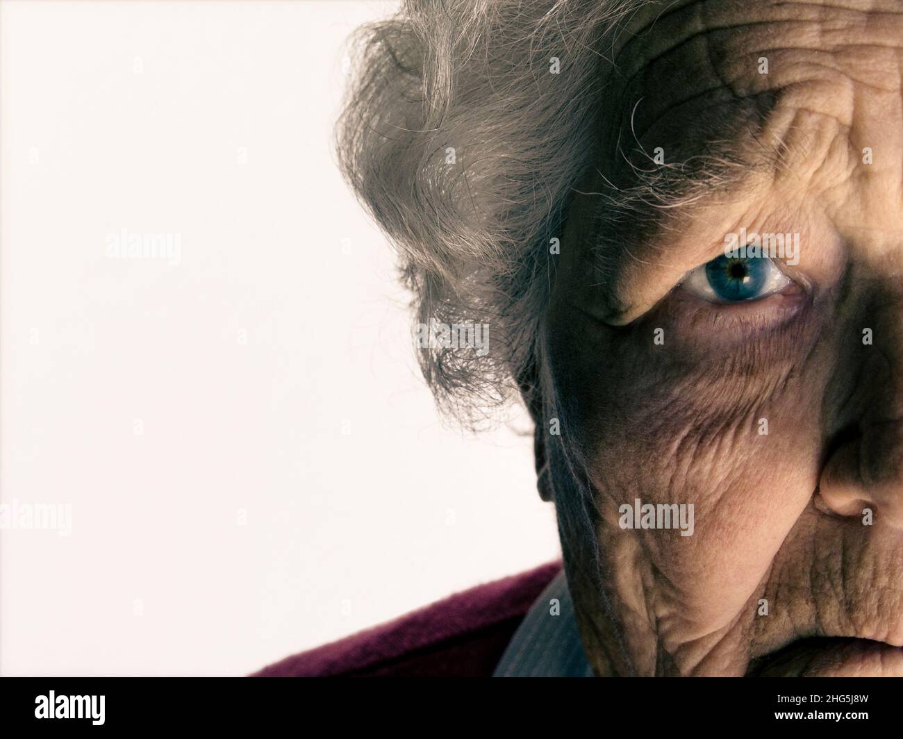 Pensive Senior old age lady elderly half face old age vulnerable lady sad eye close grey hair close view portrait, Stock Photo