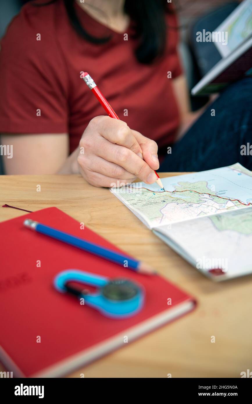Person planning a trip with a map and a guidebook Stock Photo