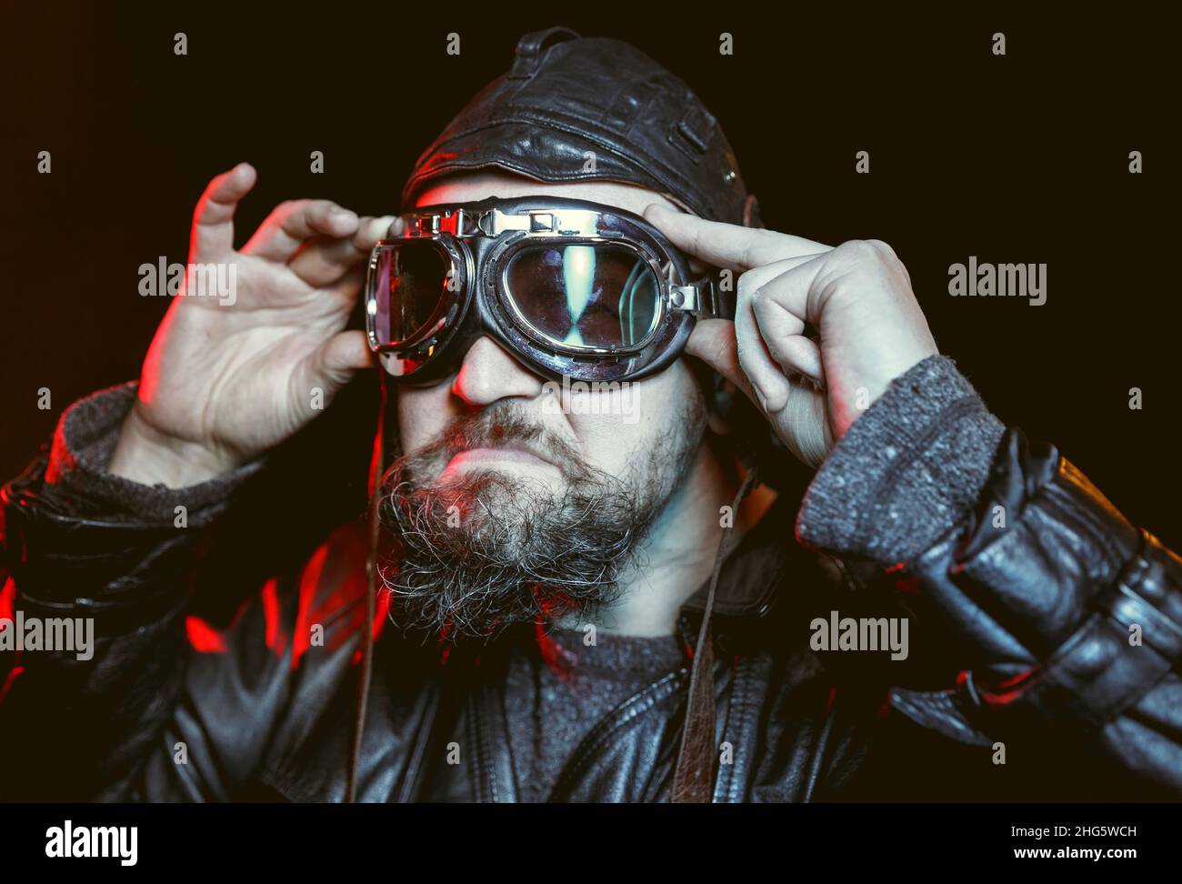 Portrait of retro angry driver with beard wearing vintage glasses and leather helmet. Automotive retro nostalgy concept Stock Photo