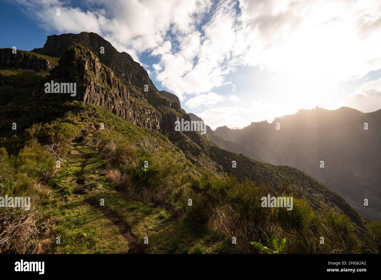 Beautiful mountainscape at dawn, showing a path section of the “Vereda da Encumeada” hiking trail, leading towards Pico Ferreiro, Madeira Stock Photo