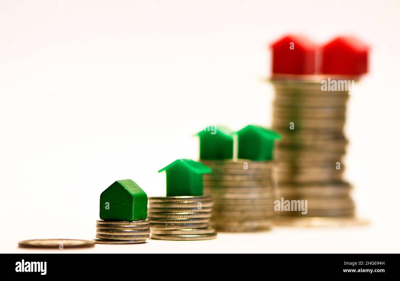 Financial inequality expressed as differences in coin height differences and home ownership Stock Photo