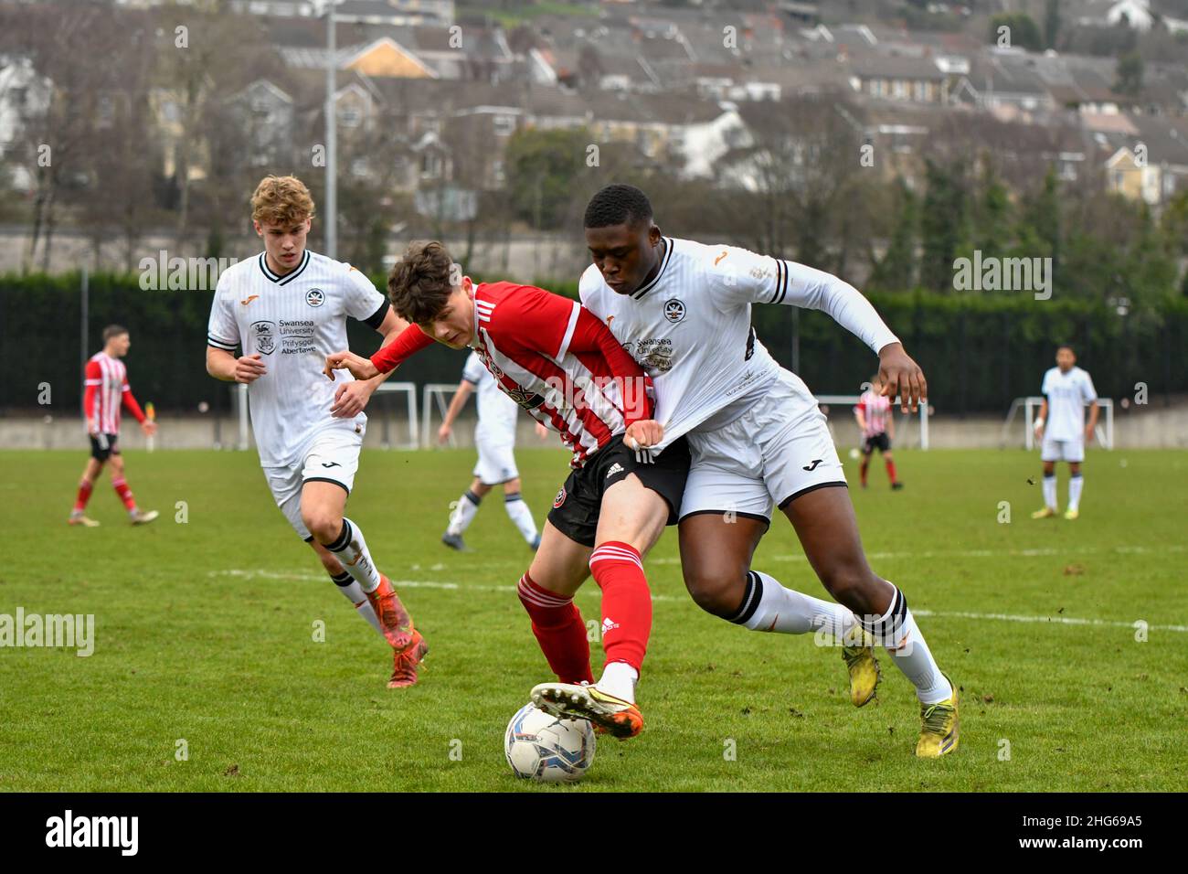 Swansea, Wales. 4 February 2023. Richard Faakye of Swansea City holds off  the challenge from Jack Howland of Millwall during the Professional  Development League game between Swansea City Under 18 and Millwall