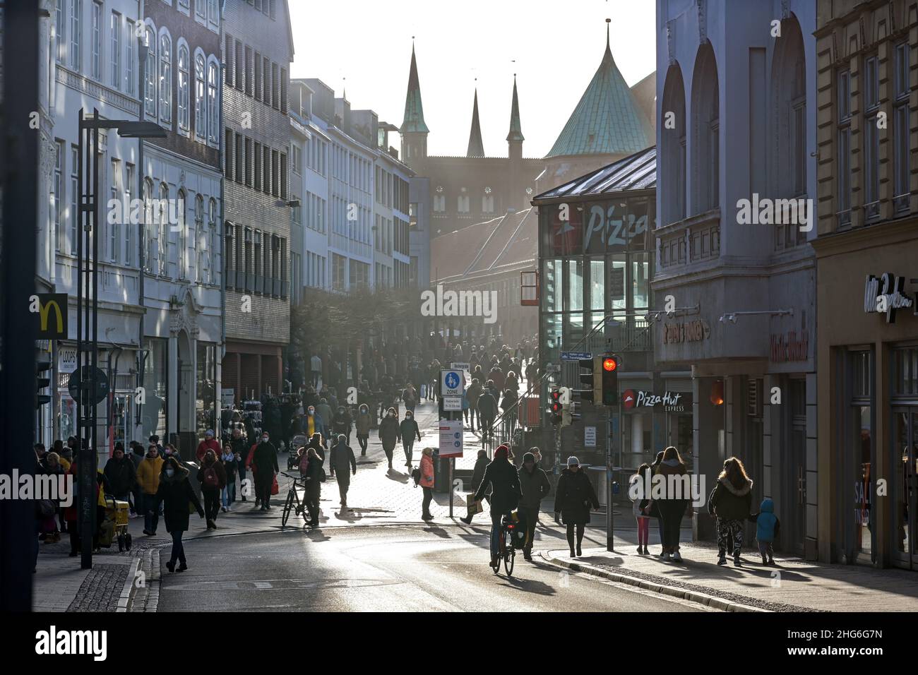 Lubeck, Germany, January 15, 2022: Crowd of people in backlight walking along the shopping street in the city center of the historic old town, selecte Stock Photo