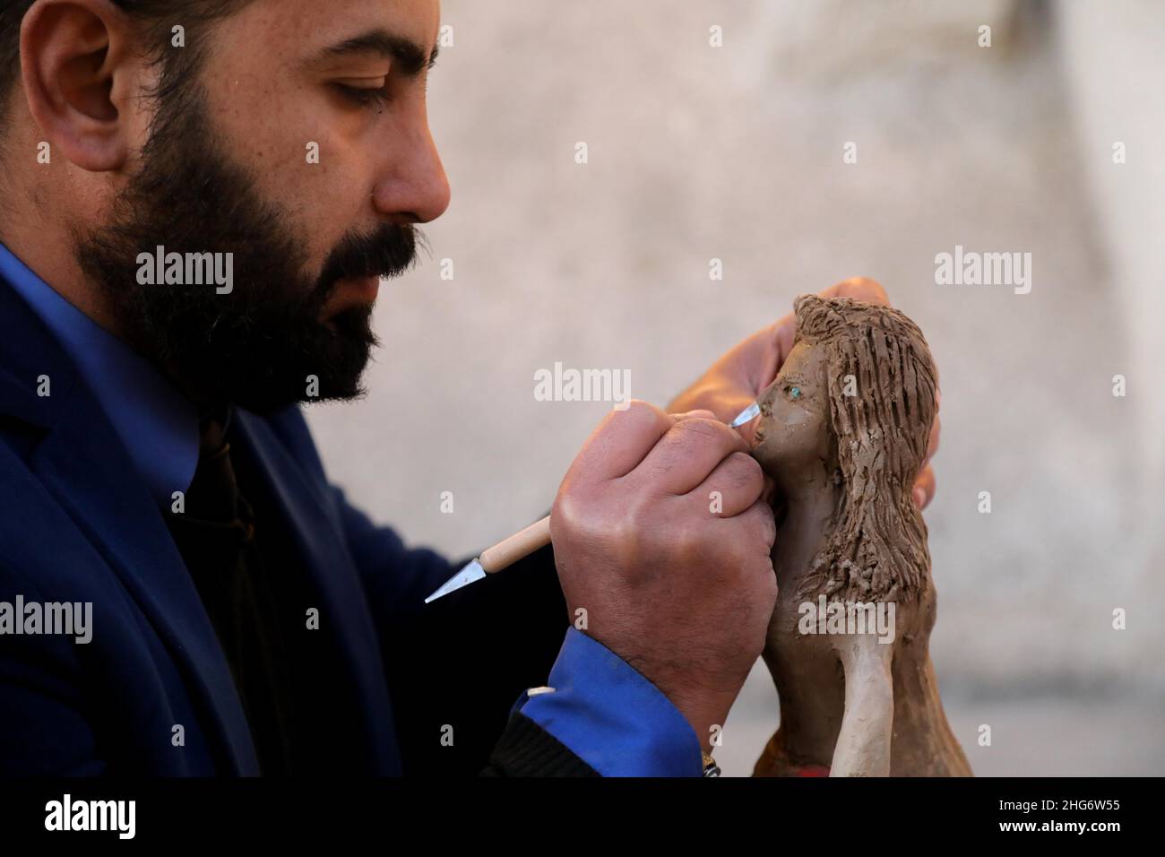 Baghdad, Iraq. 18th Jan, 2022. An artist sculpts a clay statue during a cultural evening event on Mutanabi Street in central Baghdad, Iraq, on Jan. 18, 2022. Credit: Khalil Dawood/Xinhua/Alamy Live News Stock Photo