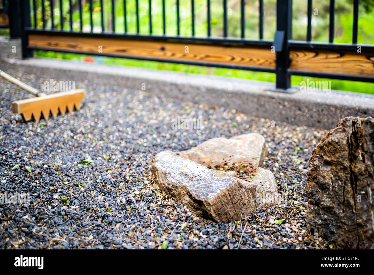 Outdoor zen rock stone Japanese garden in Japan temple with rake nobody on gravel with fence and green foliage background Stock Photo