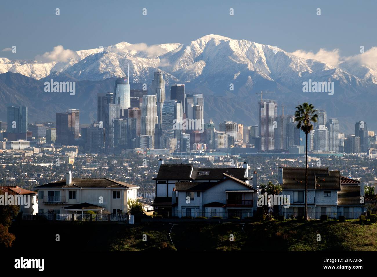 Snow capped peaks of the San Gabriel Mountains behind the downtown Los Angeles city skyline on a clear day Stock Photo