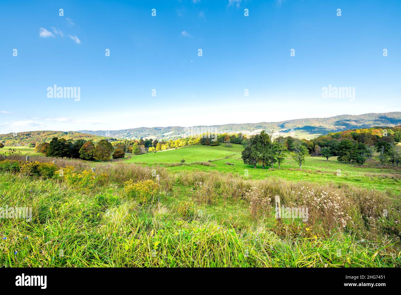 High wide angle view of rural countryside farm rolling hills at autumn fall color leaf trees in Appalachian mountains pastoral landscape in Blue Grass Stock Photo
