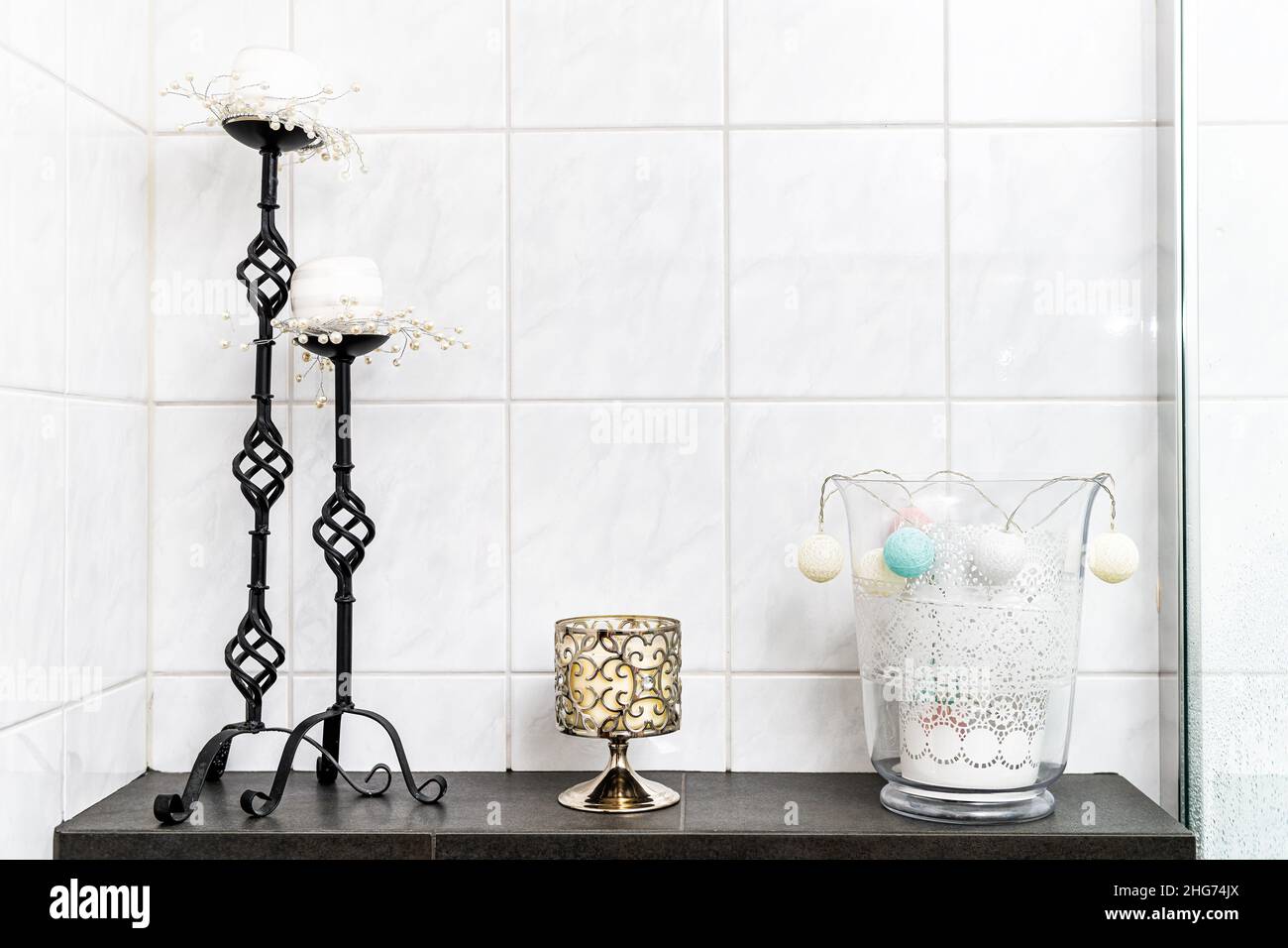 https://c8.alamy.com/comp/2HG74JX/white-bathroom-tiles-tiled-wall-interior-bright-natural-light-design-and-candle-holder-object-candelabra-decorations-modern-contemporary-on-shelf-tabl-2HG74JX.jpg