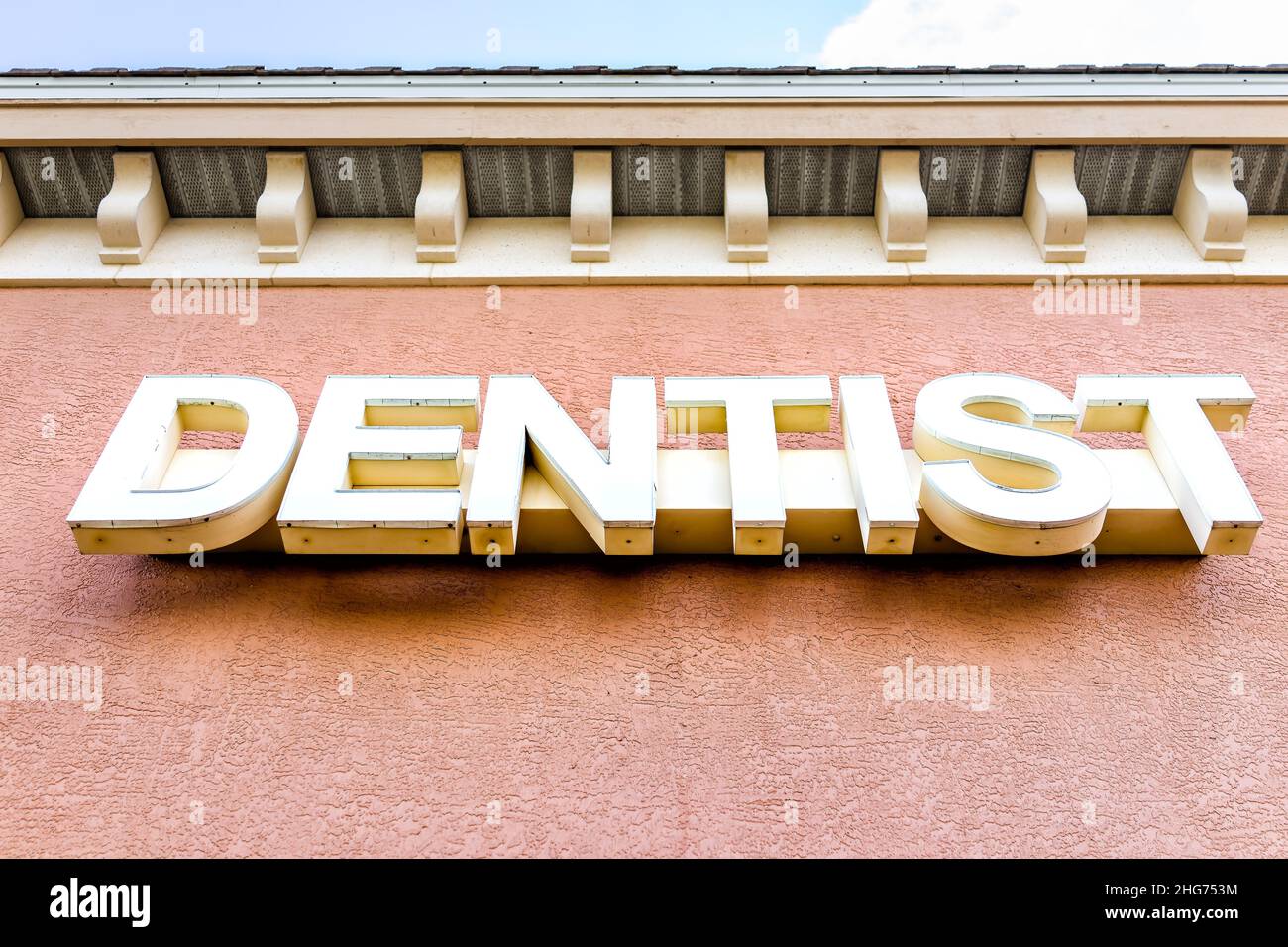 Sign for Dentist word in big letters low angle view looking up at entrance to strip mall building and nobody Stock Photo
