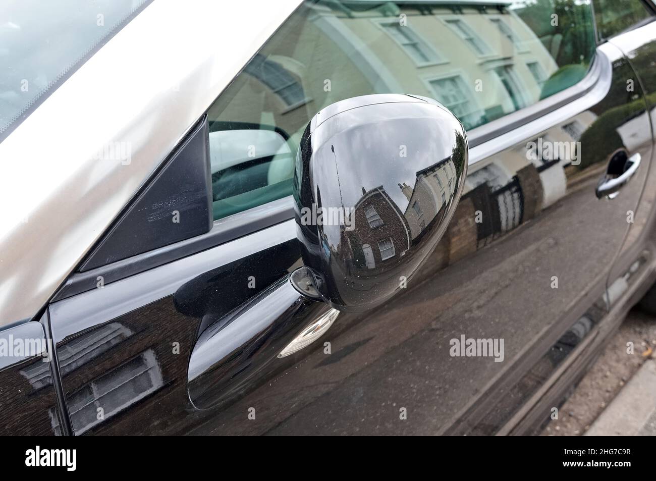 passenger door with wing mirror of a black Peugeot RCZ coupe. Stock Photo