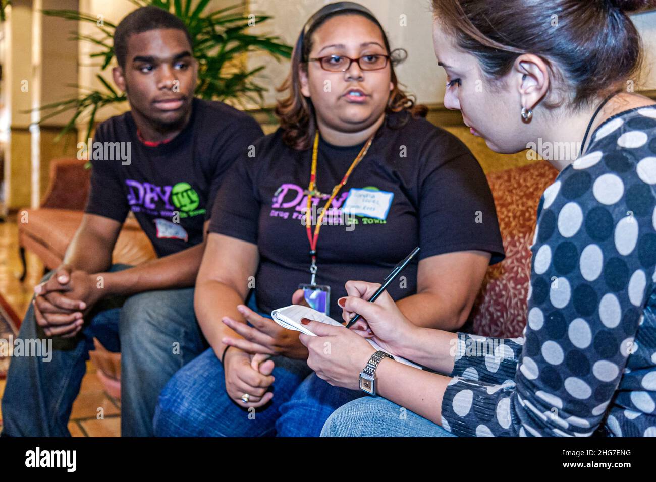 Miami Florida,Drug Free Youth In Town abuse prevention program students teens newspaper reporter interviewing,Black Hispanic boy girl asking questions Stock Photo