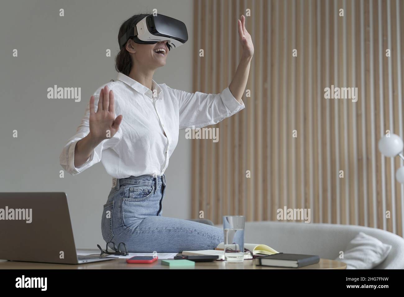 Young amazed businesswoman in virtual reality glasses testing innovative method for business Stock Photo