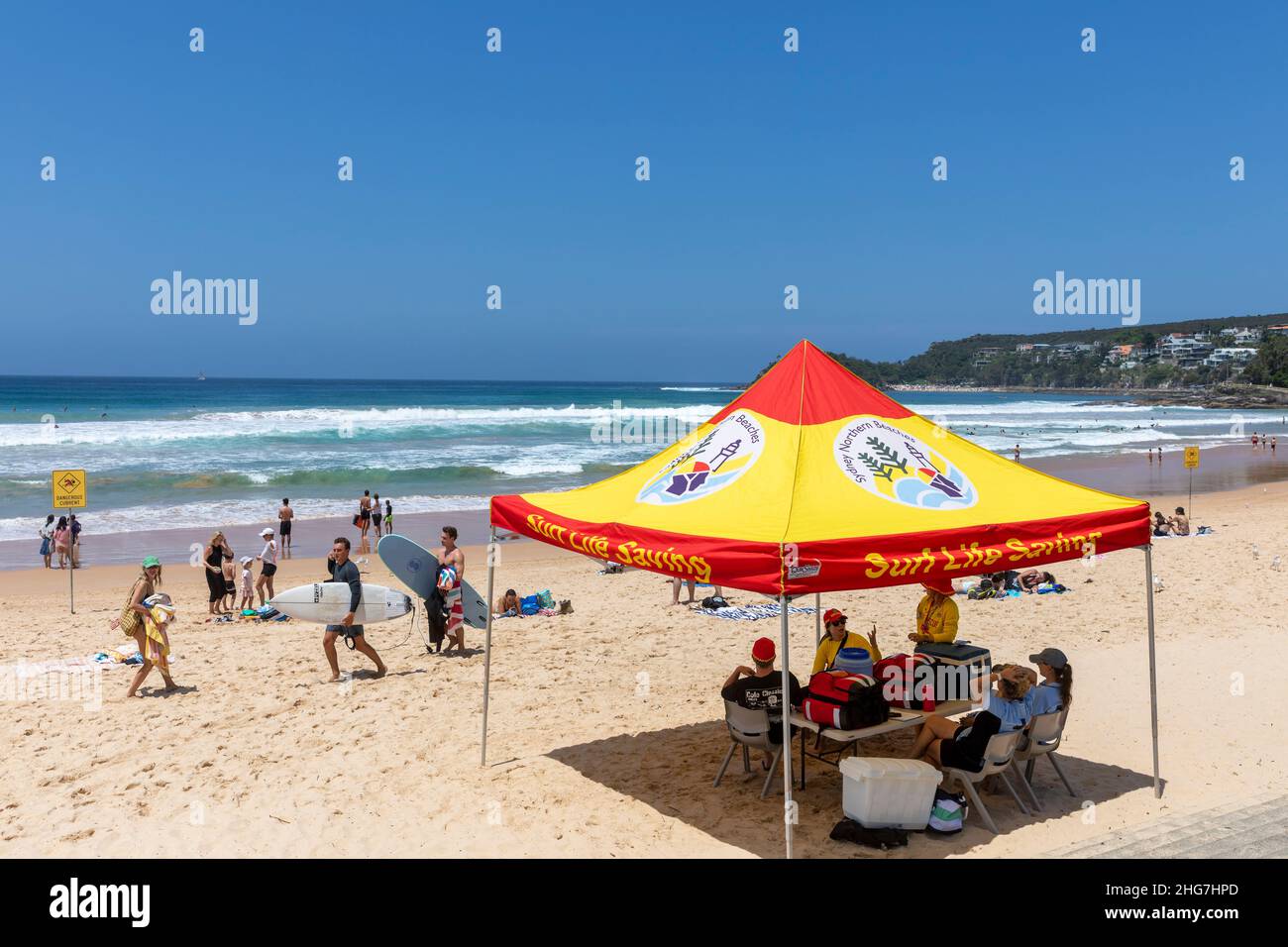 Surf life saving team of volunteers and council lifeguards on Manly Beach Sydney in summer and taking shade under the tent,Sydney,Australia Stock Photo