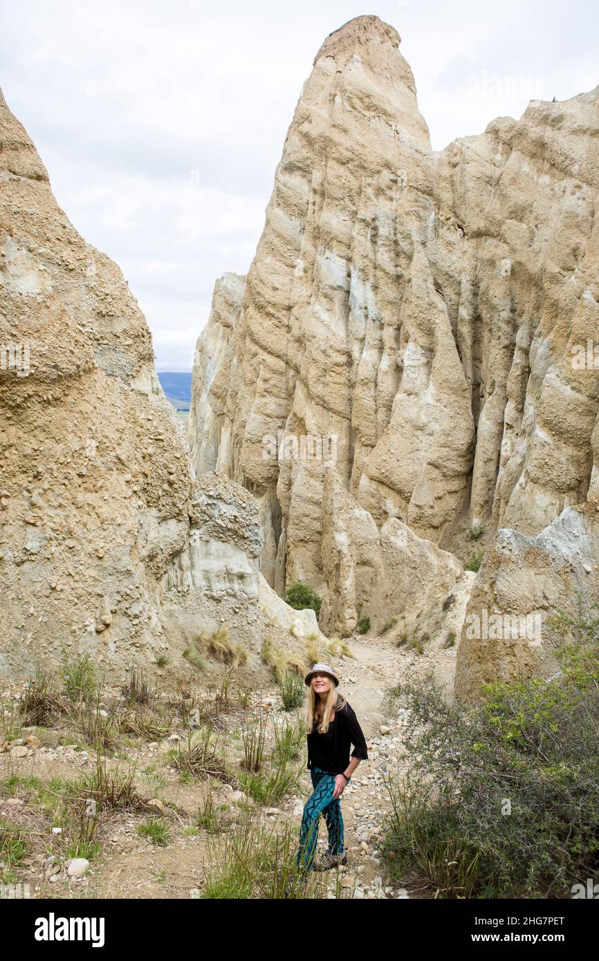 Woman standing in the Omarama Clay Cliffs, New Zealand. Stock Photo