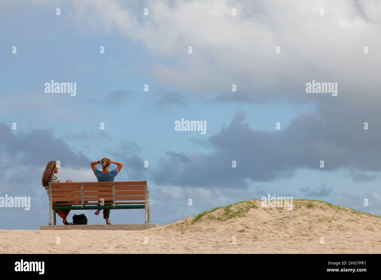 Two Women Talking on a Bench, Kailua Beach, O'ahu, HI, US Stock Photo
