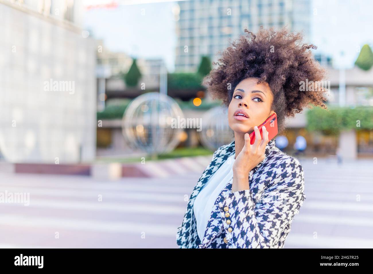 distracted woman looking away while talking on the phone Stock Photo