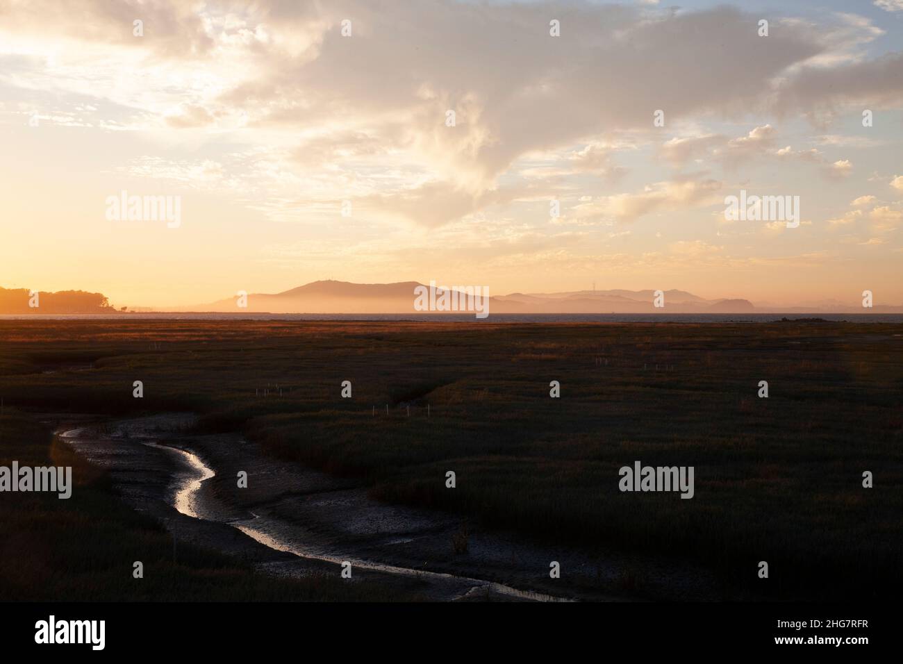 Wetlands' Waterway and Distant Mountain Range at Sunset, CA Stock Photo