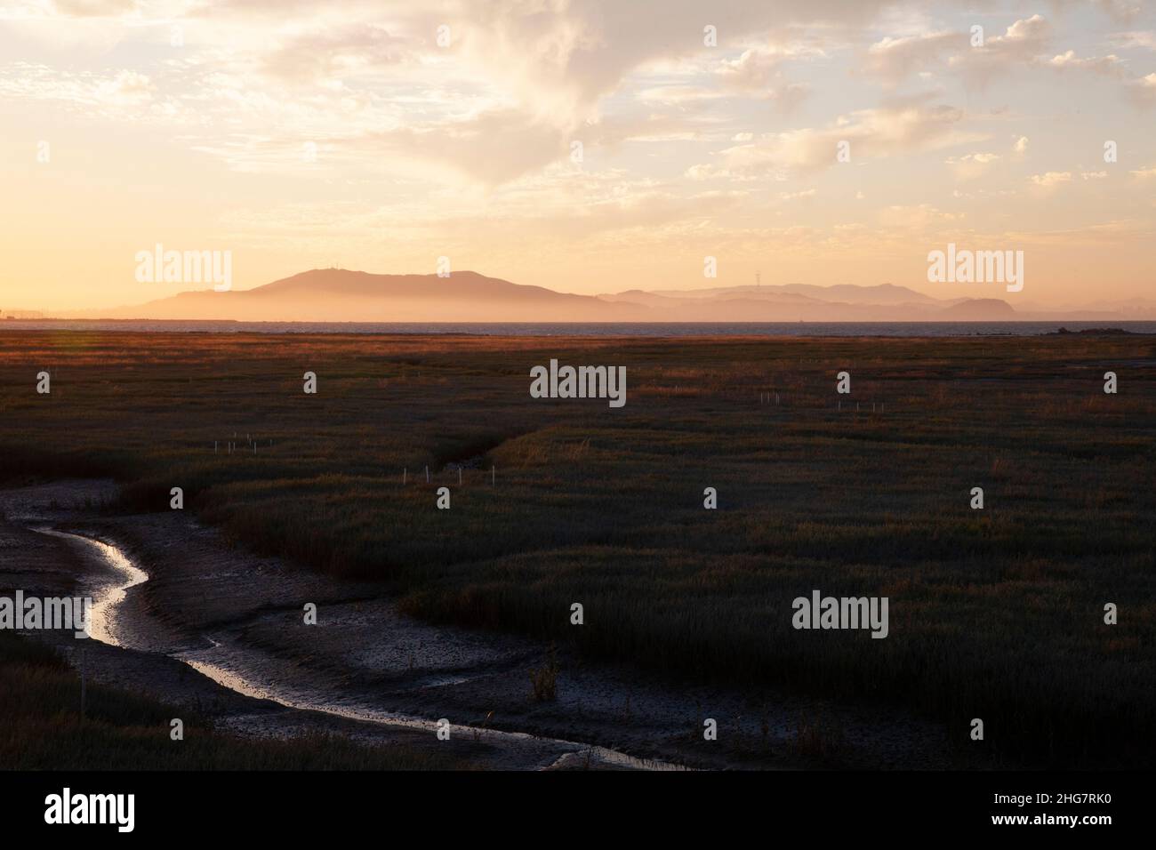 Waterway in Wetlands with Distant Mountain Range at Sunset, CA Stock Photo