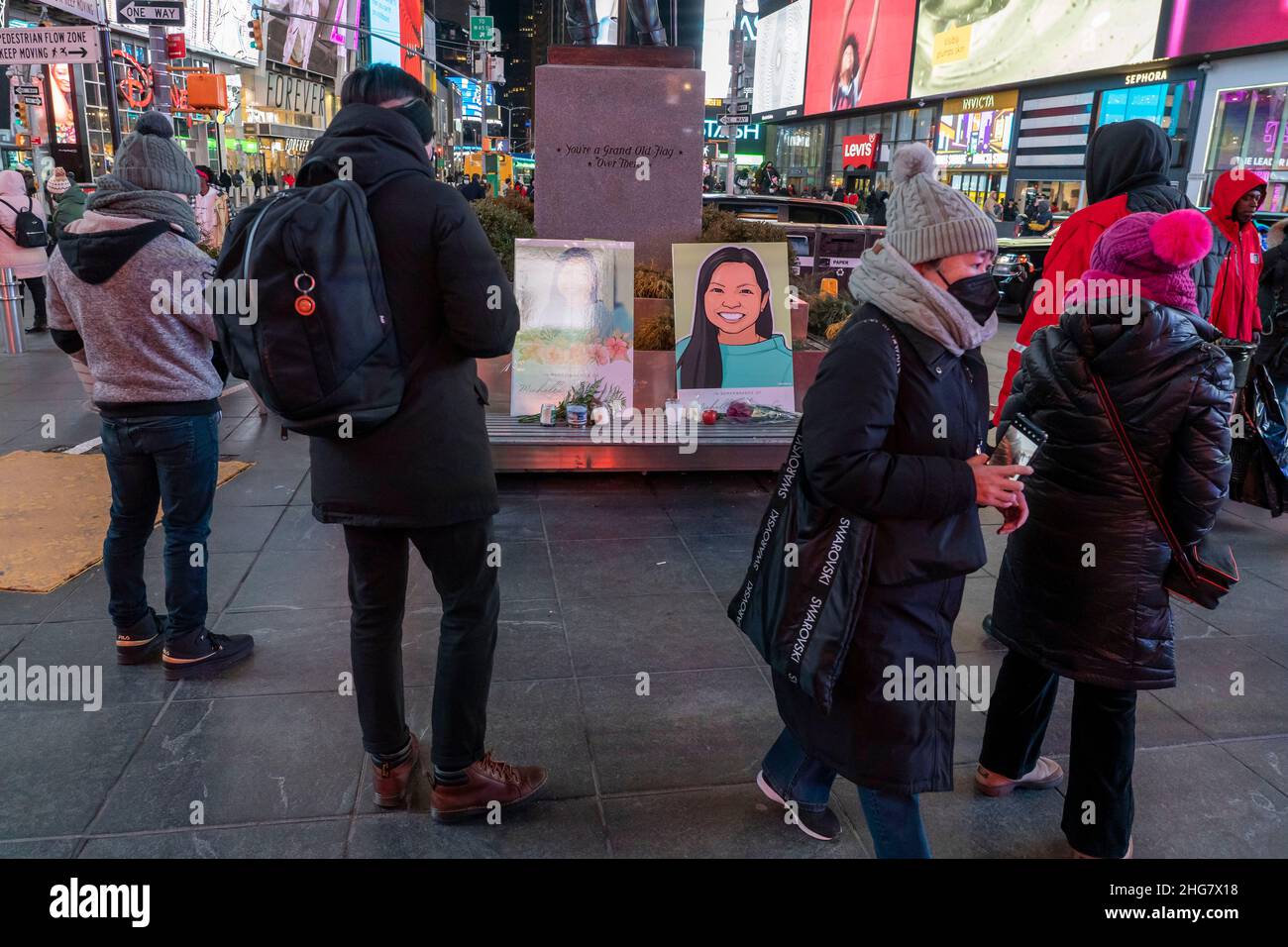 Attendees and by passers look at a make shift memorial during a
