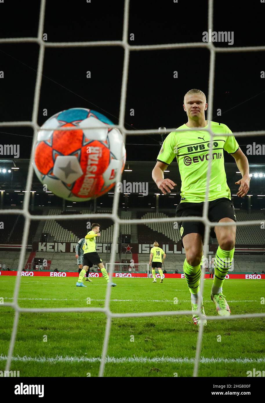 18 January 2022, Hamburg: Soccer: DFB Cup, Round of 16, FC St. Pauli - Borussia Dortmund at Millerntor Stadium. Dortmund's Erling Haaland runs into the goal after his penalty goal for 2:1 and collects the ball. (IMPORTANT NOTE: In accordance with the requirements of the DFL Deutsche Fußball Liga and the DFB Deutscher Fußball-Bund, it is prohibited to use or have used photographs taken in the stadium and/or of the match in the form of sequence pictures and/or video-like photo series). Photo: Christian Charisius/dpa - IMPORTANT NOTE: In accordance with the requirements of the DFL Deutsche Fußbal Stock Photo