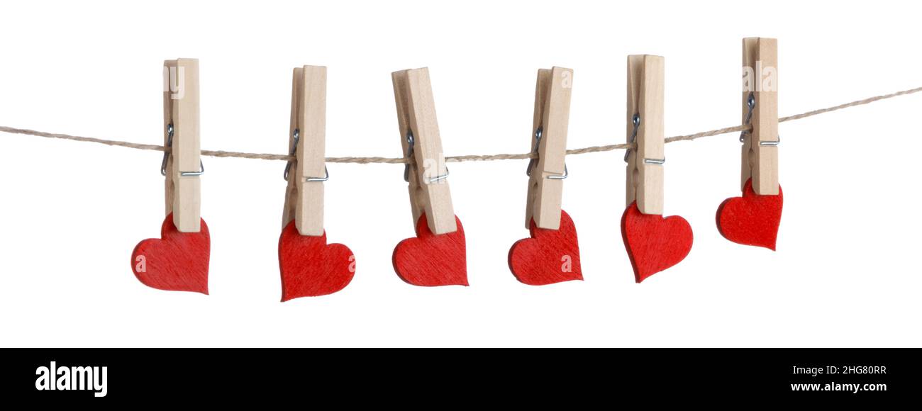 Clothes pegs and red wooden hearts on rope isolated on white background Stock Photo