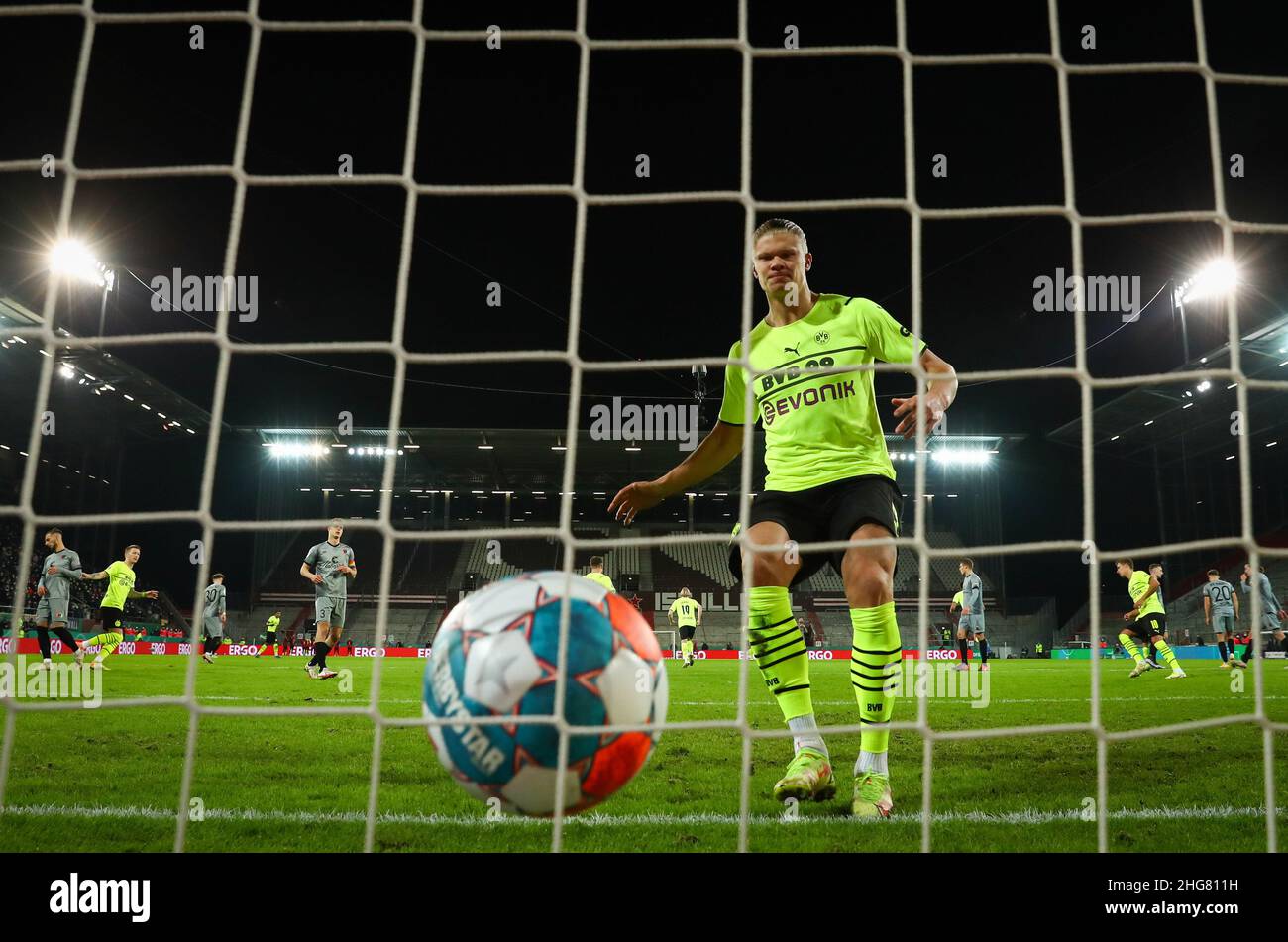18 January 2022, Hamburg: Soccer: DFB Cup, Round of 16, FC St. Pauli - Borussia Dortmund at Millerntor Stadium. Dortmund's Erling Haaland runs into the goal after his penalty goal for 2:1 and collects the ball. (IMPORTANT NOTE: In accordance with the requirements of the DFL Deutsche Fußball Liga and the DFB Deutscher Fußball-Bund, it is prohibited to use or have used photographs taken in the stadium and/or of the match in the form of sequence pictures and/or video-like photo series). Photo: Christian Charisius/dpa - IMPORTANT NOTE: In accordance with the requirements of the DFL Deutsche Fußbal Stock Photo