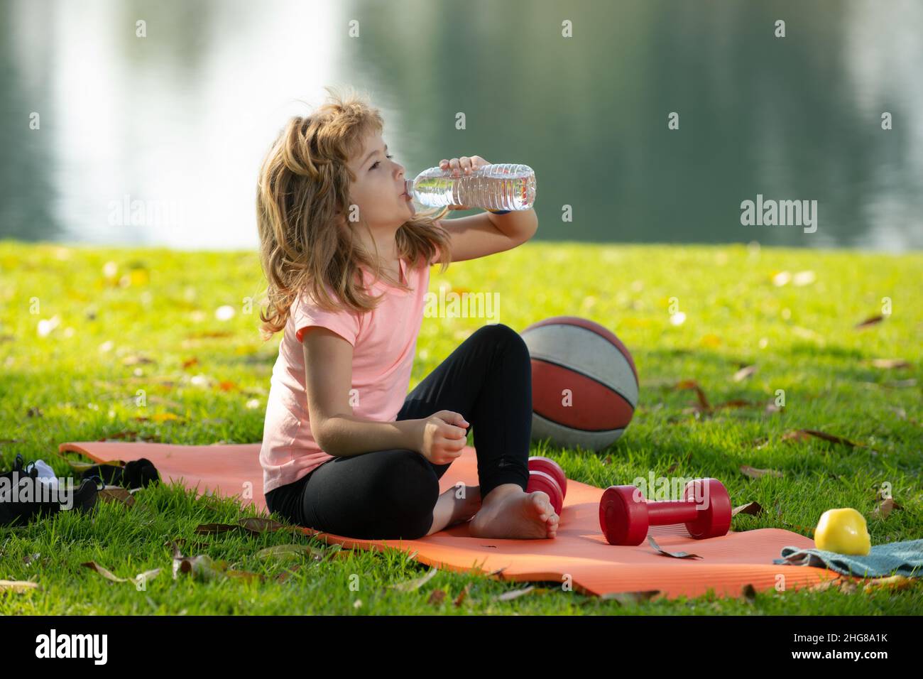 Kids relax on sport mat after sport exercises drink water outdoor in park  Stock Photo - Alamy