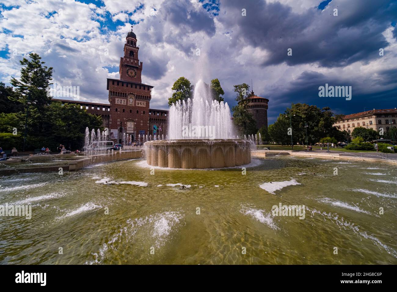 The Castello Sforzesco, Sforza's Castle, located at Piazza Castello, seen over a fountain, a thunderstorm is coming. Stock Photo