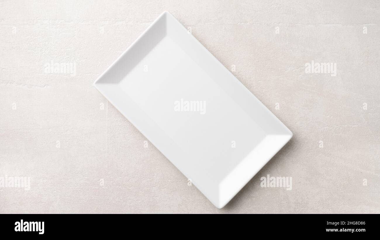 Rectangular white plate on a light stone background, the concept of ...