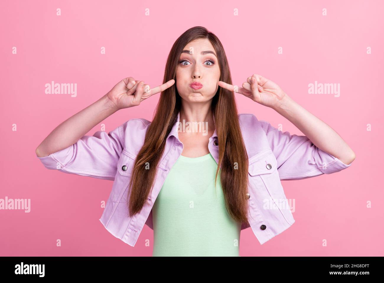 Photo portrait woman holding ait in cheeks pointing fingers isolated pastel pink color background Stock Photo