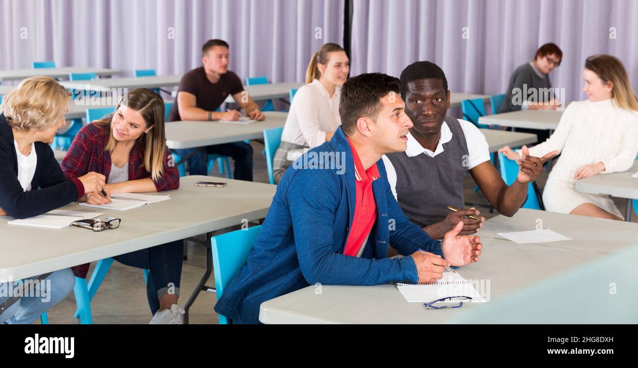 Adult students discussing lesson Stock Photo - Alamy