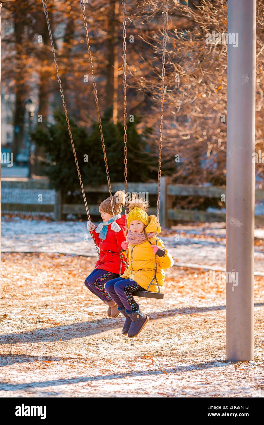 Adorable little girls having fun on the swing in Central Park at New