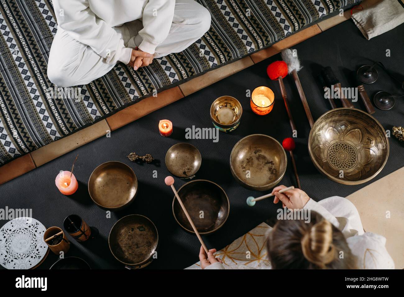 Singing bowls top view, sound healing alternative therapy. Woman playing on percussion metal music instruments. Mental health care with meditation Stock Photo