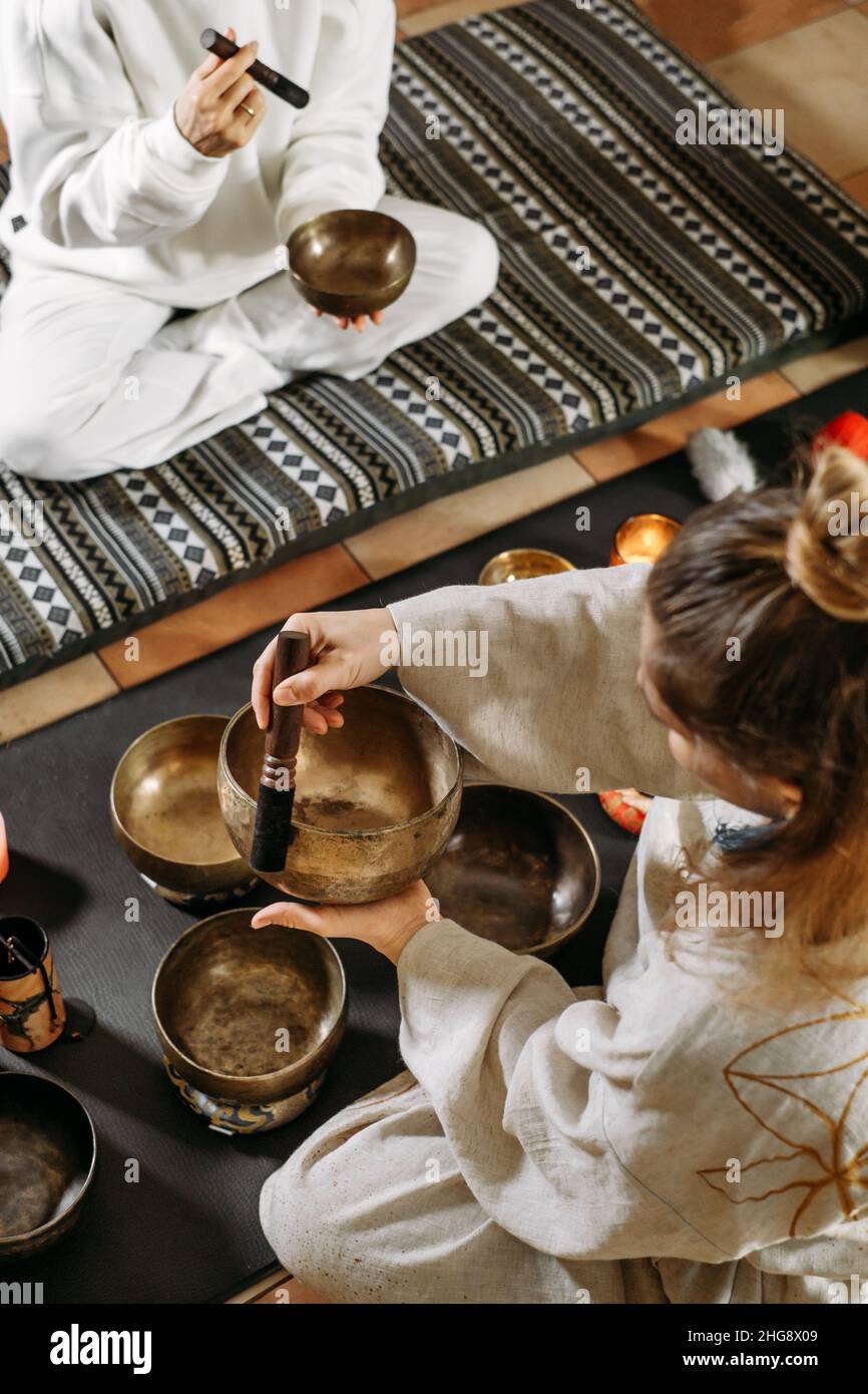 Singing bowls top view, sound healing alternative therapy. Woman