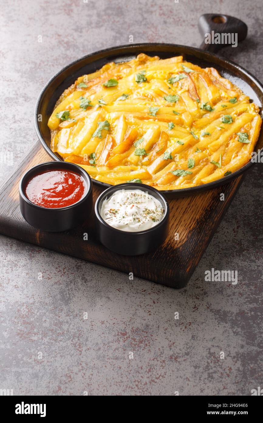 Tanzanian special dish Chips Mayai French Fries Omelette close up in the plate on the table. Vertical Stock Photo