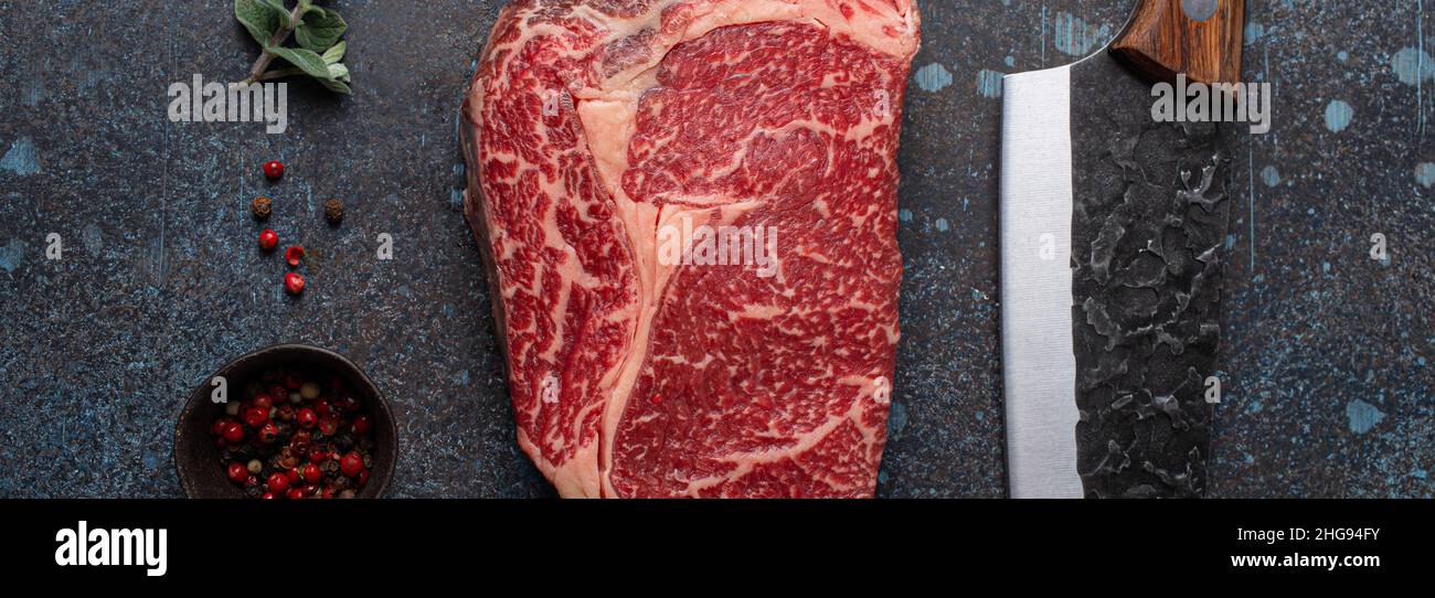 Raw meat beef marbled prime cut steak Ribeye on rustic concrete kitchen table Stock Photo