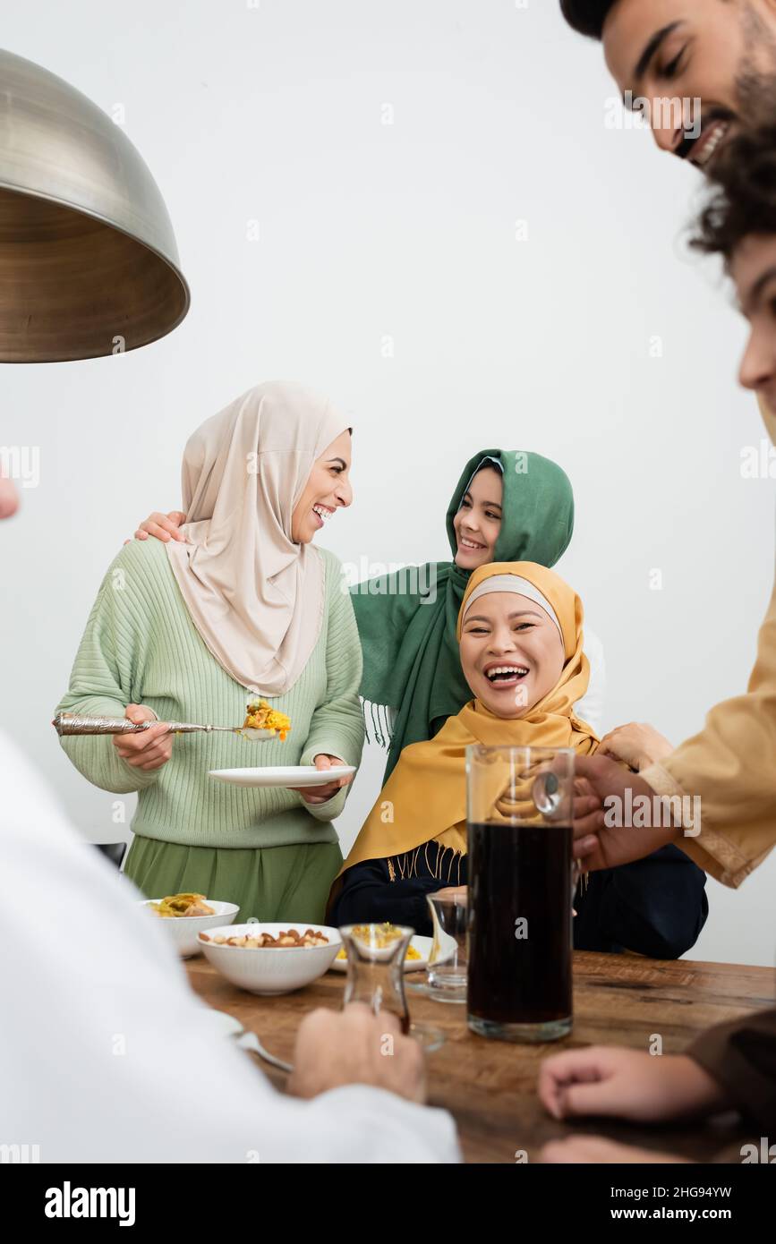 Cheerful multiethnic muslim family talking near food at home Stock Photo