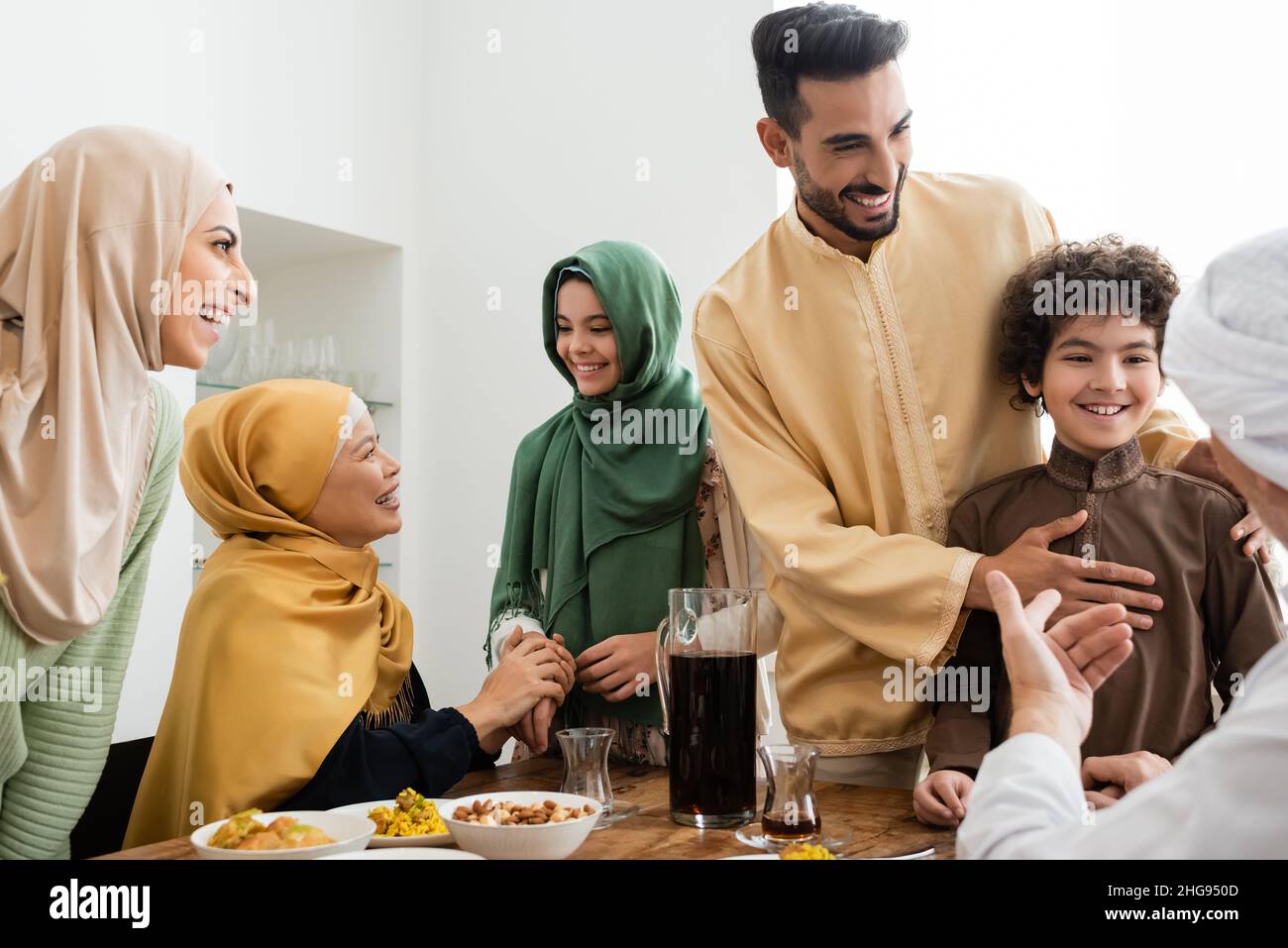 Happy interracial muslim family talking near food at home Stock Photo