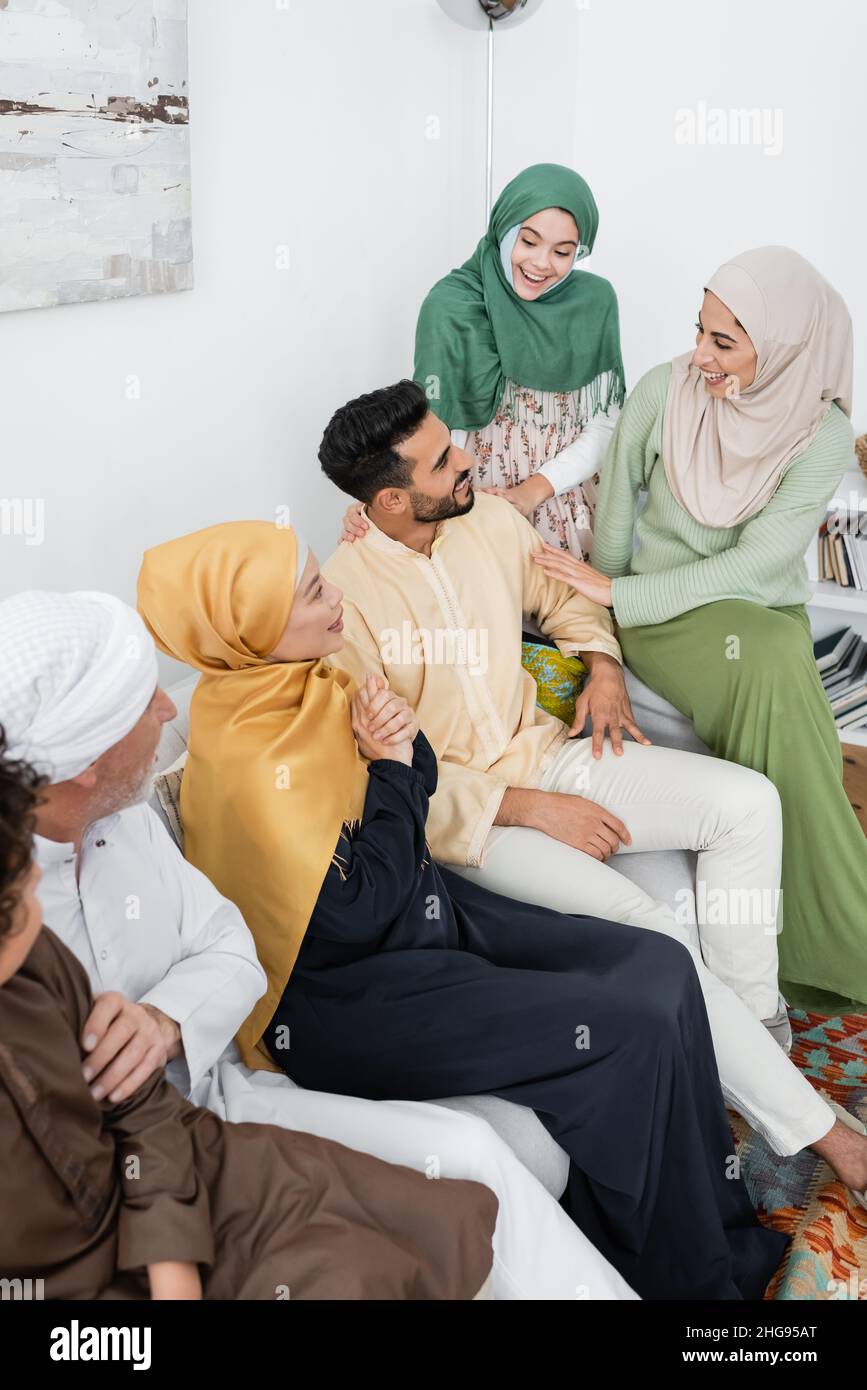 high angle view of arabian woman laughing near husband and multiethnic family at home Stock Photo