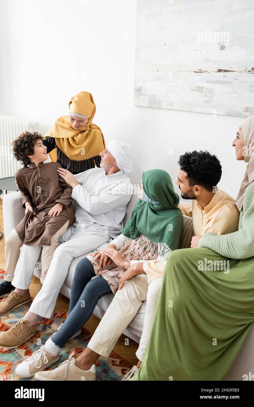 mature man talking to arabian grandson near wife and multicultural muslim family Stock Photo