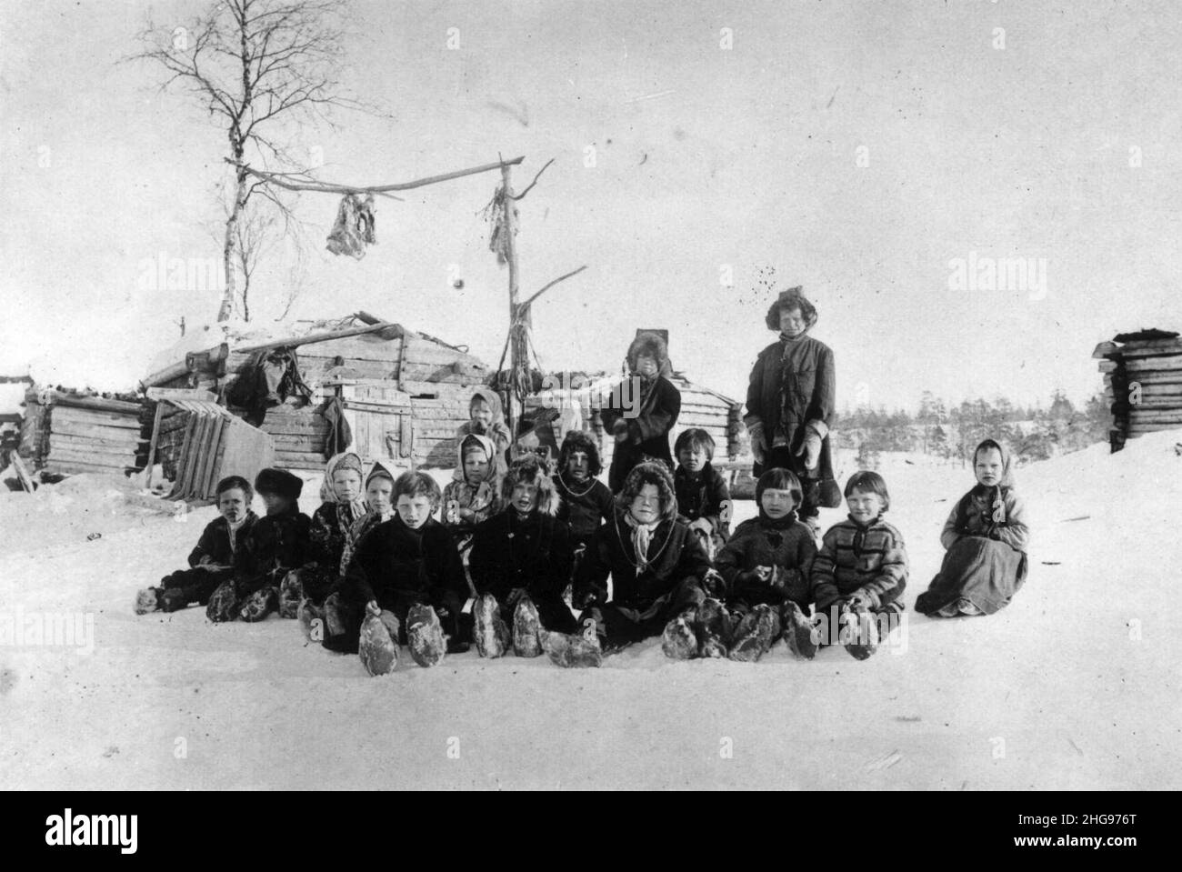 Skoltesamiske skolebarn sitter i snøen ved Pasvik-siidaens skole, Pasvik, Sør-Varanger, Finnmark Stock Photo