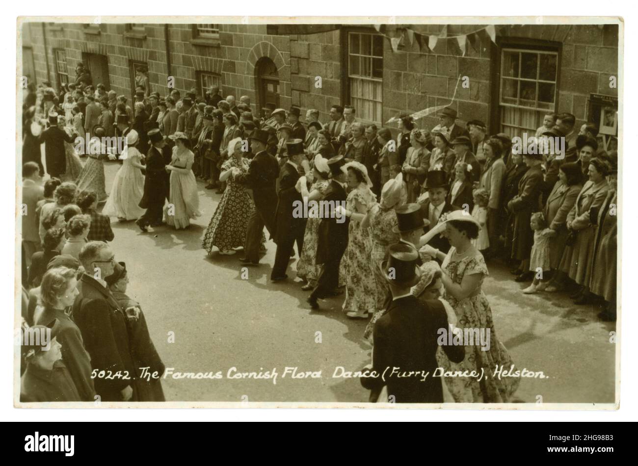 Original 1950's greetings postcard photo of the famous Cornish Flora Day dance (Furry Dance) a traditional festival which dates back to Pagan times. Dancers are traditionally dressed in their Sunday best, the men in shirt and tie and the women in summer dresses. It celebrates the arrival of spring and takes place in the month of May in Helston, Cornwall, England, U.K. posted 5 July 1952. Stock Photo