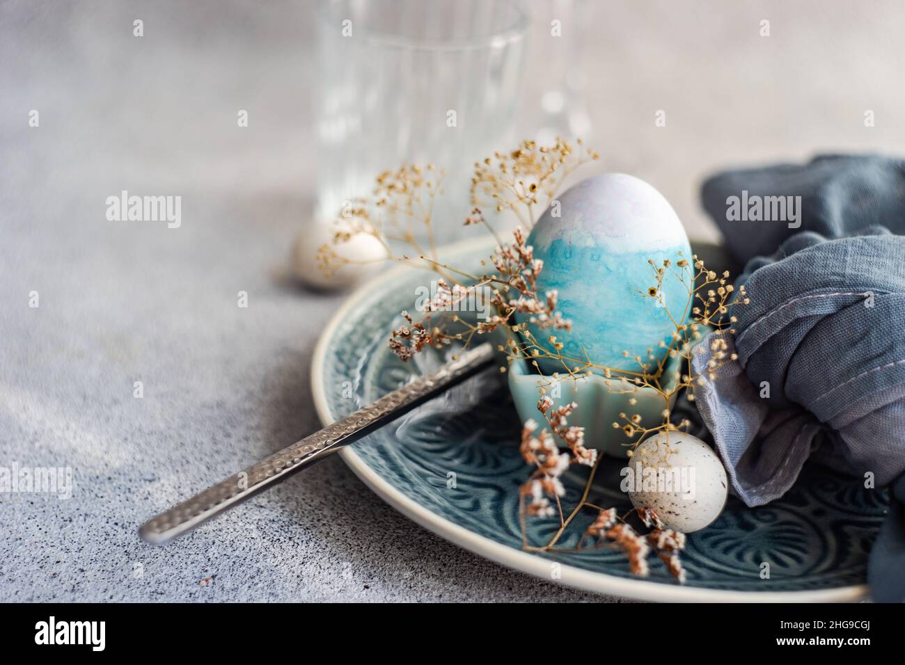 Festive Easter place setting with painted Easter eggs and dried flowers Stock Photo